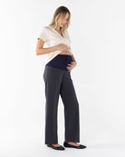 Pregnant woman in casual outfit on a white background
