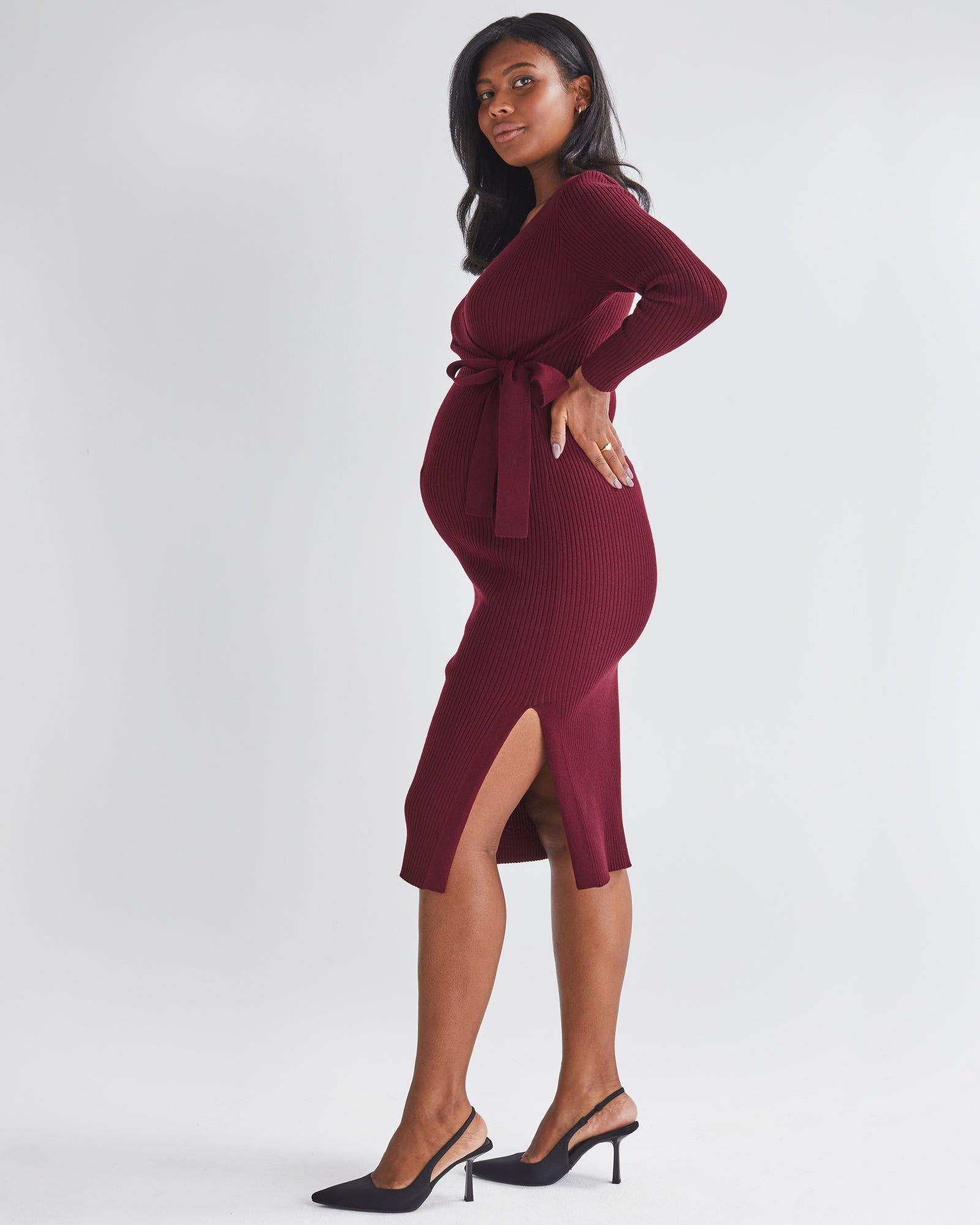 Side View - A Pregnannt Woman Wearing Lucille Full Sleeve Knit Maternity Midi Dress in Burgundy  from Angel Maternity.