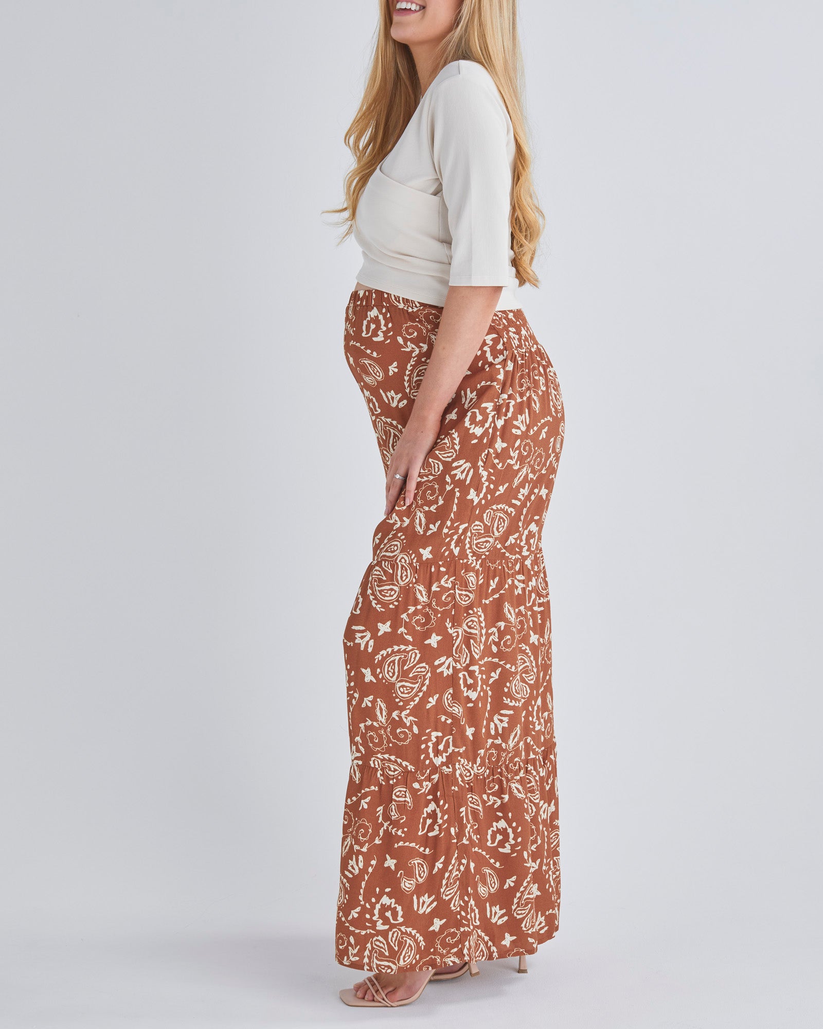 Side View - A Pregnant Woman Wearing Stacie Wide Leg Maternity Ruffled Pants in Paisley Print from Angel Maternity