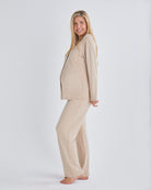 Side view - A pregnant woman wearing button front nursing freindly pyjama set in pink from Angel Maternity.