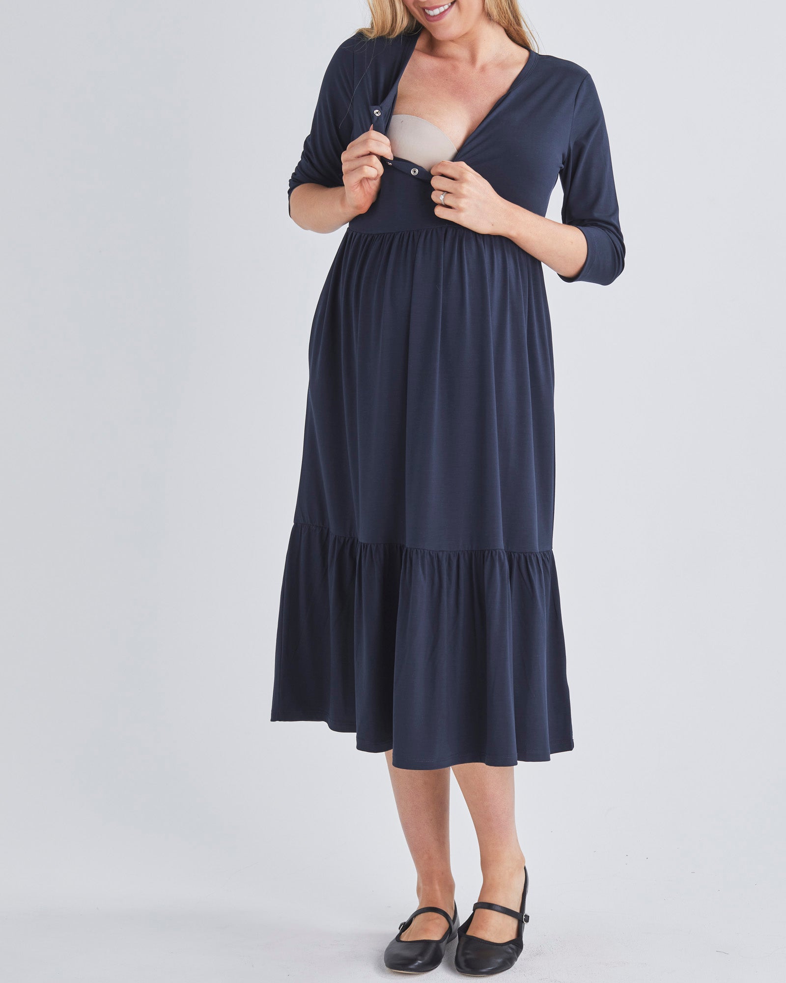 A Woment Wearing Tiered Maternity Midi Dress in Navy from Angel Maternity Australia Showing Easy Breastfeeding Access.