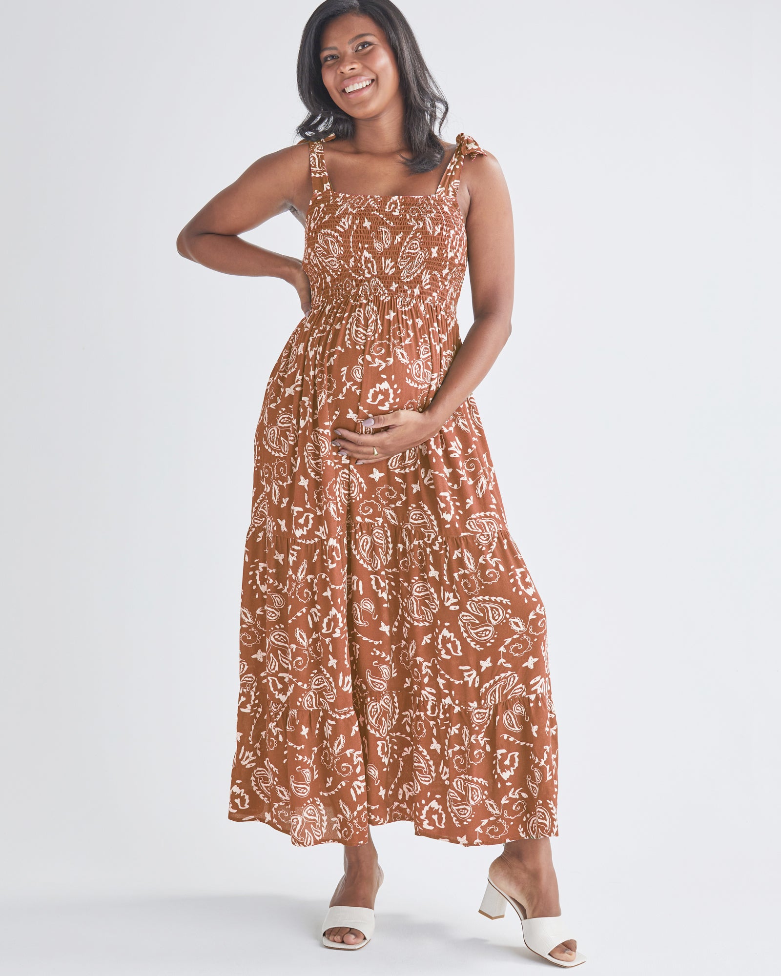 A pregnant Woman Wearing Maternity Maxi Dress in Brown Paisley Print from Angel Maternity