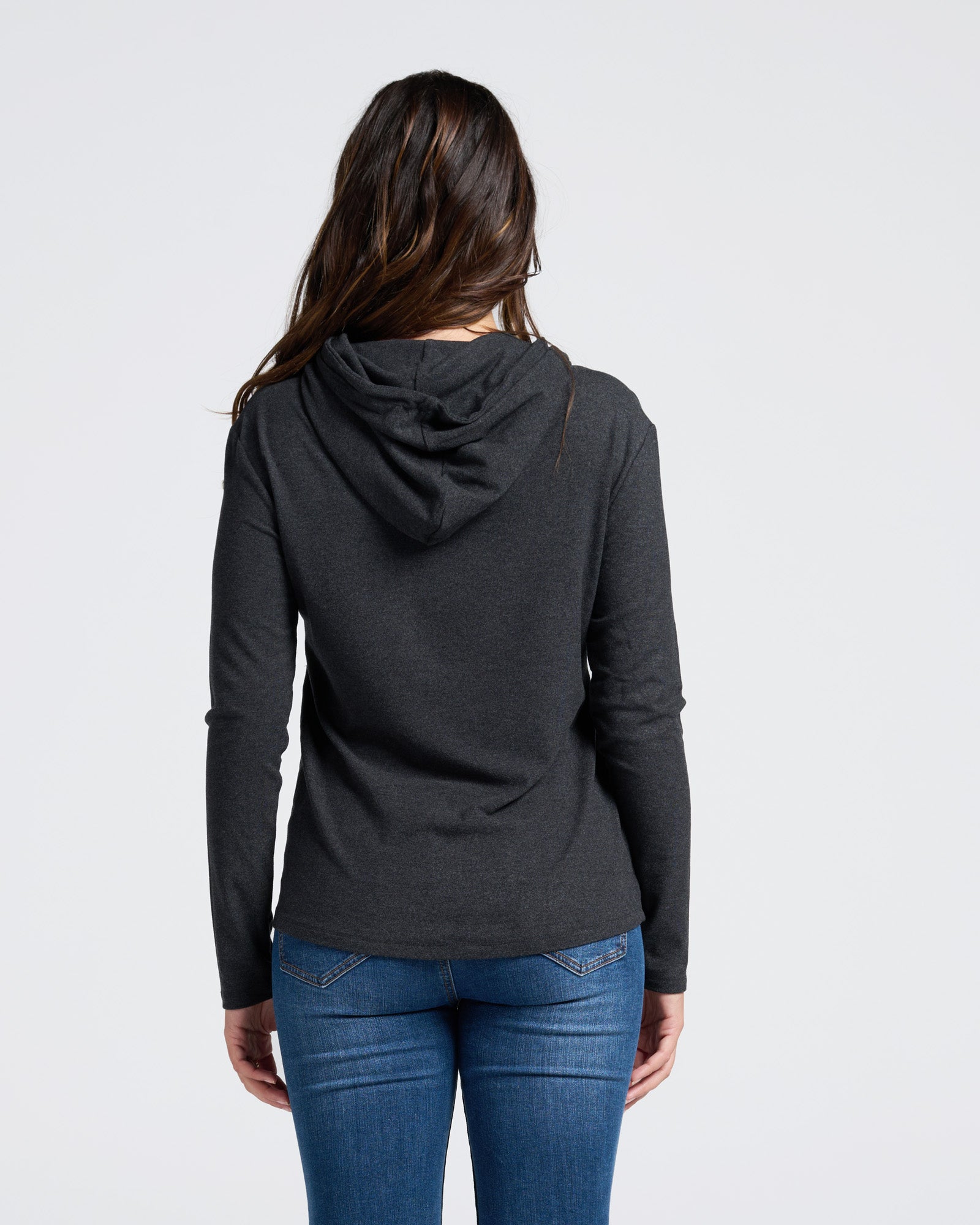 Person wearing a dark grey maternity winter hoodie and blue maternity jeans