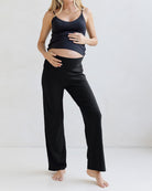 Woman wearing a black tank top and black maternity lounge pants