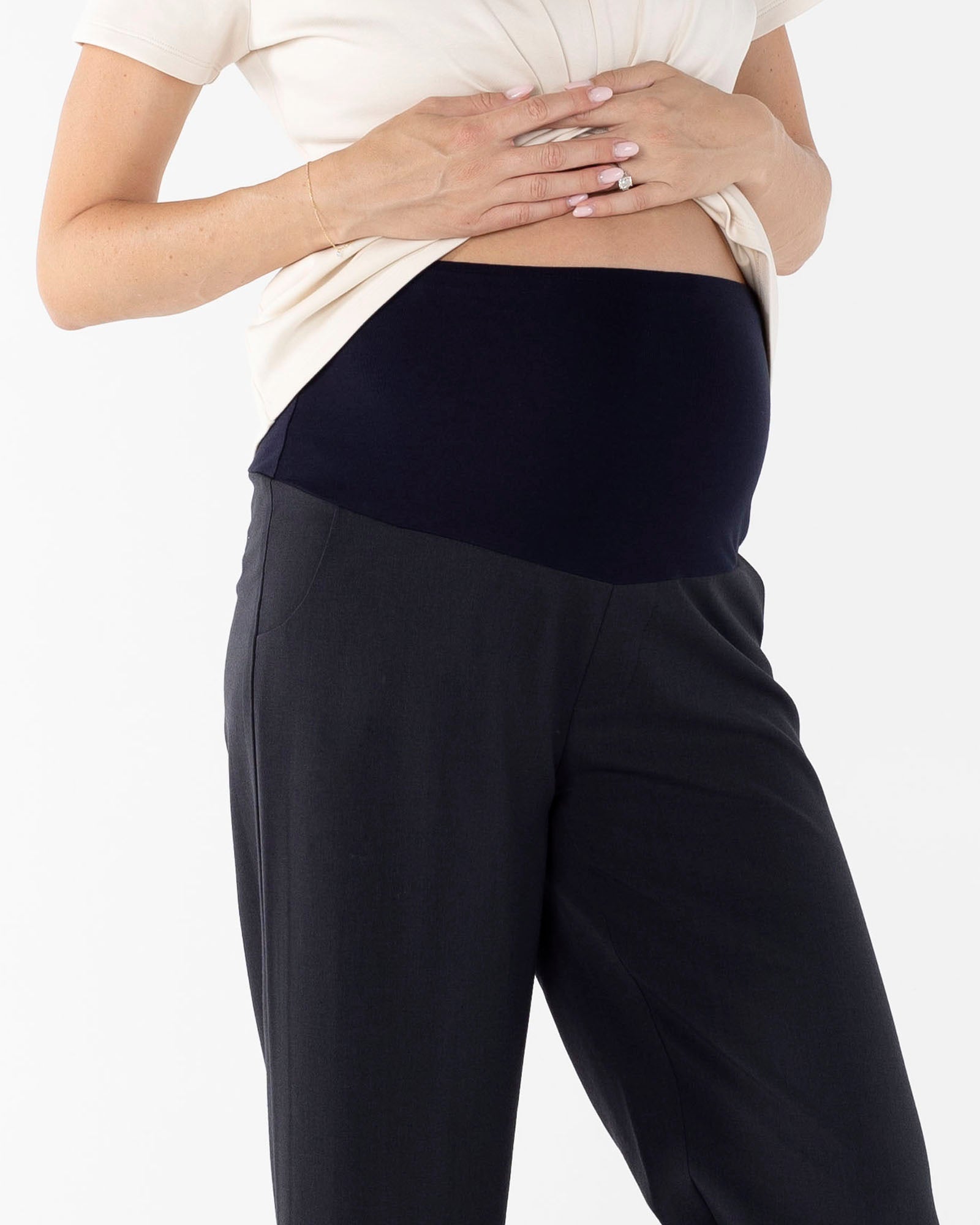 Person wearing black maternity pants with a high waist waistband.