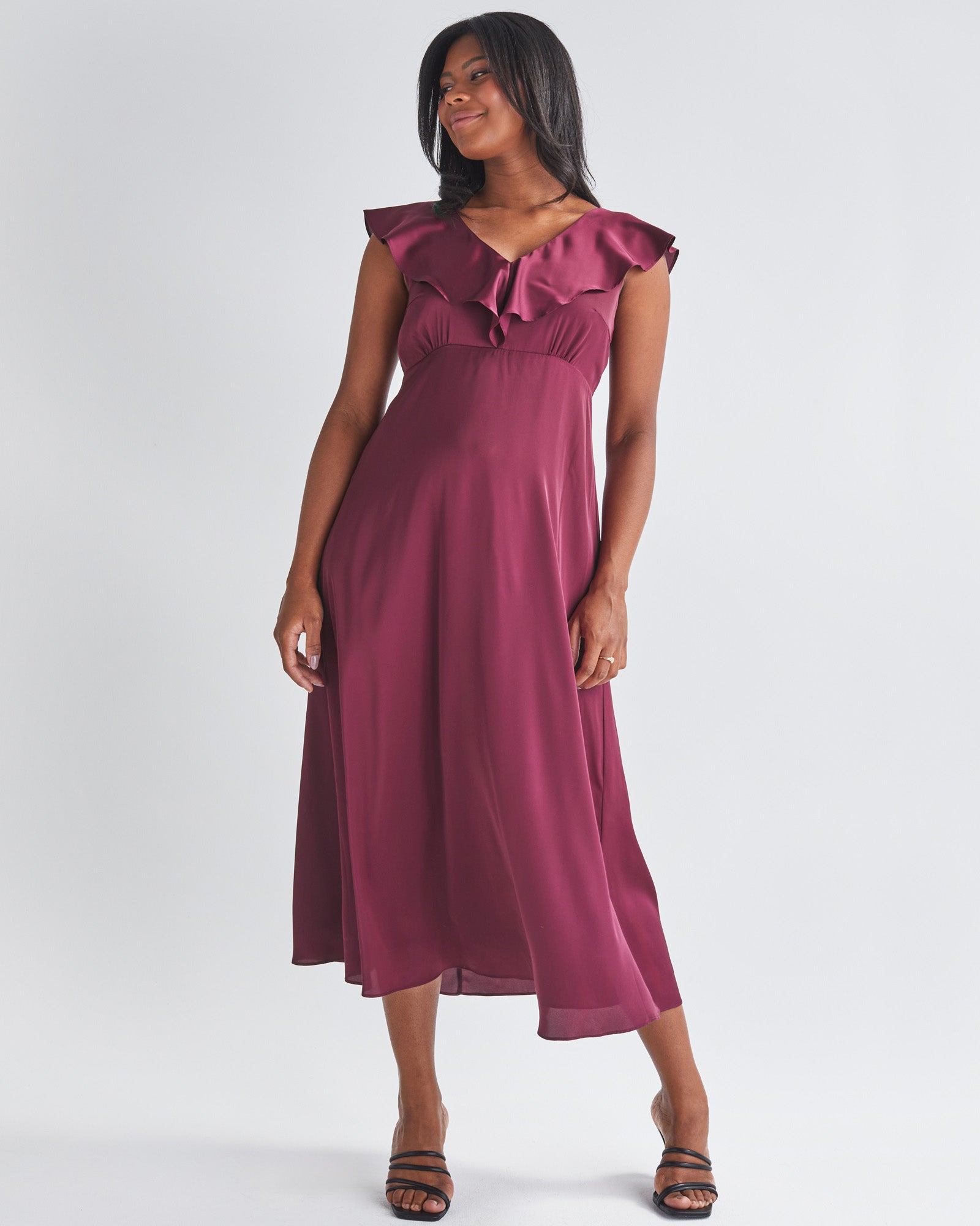 A smiling Pregnannt Woman Wearing Mika Maternity Evening Ruffle Dress in Wine from Angel Maternity