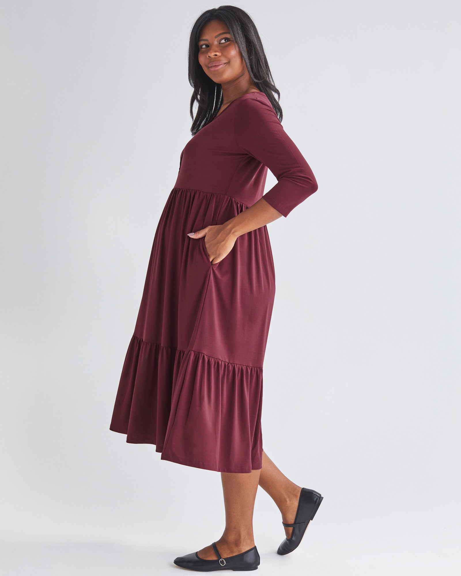 Side View - A Pregnannt Woman Wearing Tiered Maternity Midi Dress in Burgundy from Angel Maternity.