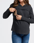 Woman wearing a black long-sleeve top with a hood on a white background