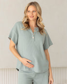 Woman wearing a light gray maternity loungewear outfit at home