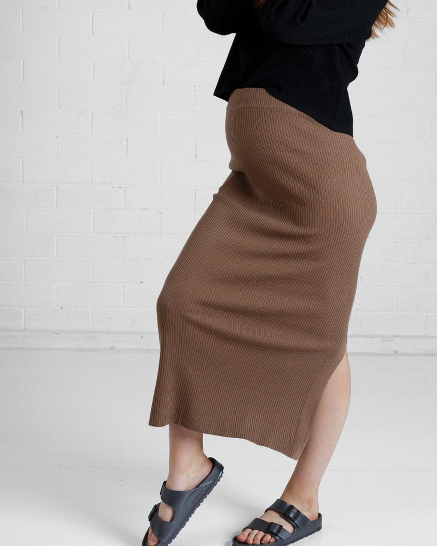 a woman in brown maternity angel maternity wool blend knit skirt with side split, side (6651643461735)