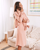 A women nursing a baby-  wearing maternity nursing friendly loungewear dress in pink