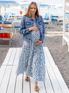 Front View - A pregnant Woman in Nursing Friendly Shoulder Tie Maternity Maxi Dress in Blue Print with Denim Jacket