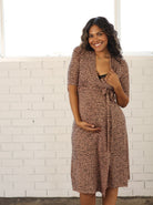 Front view - A Pregnant Woman in Classic Maternity Wrap  Dress in Brown Print smiling & showing breastfeeding access (6699013931111)