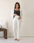 Woman in white outfit standing in a minimalistic room.