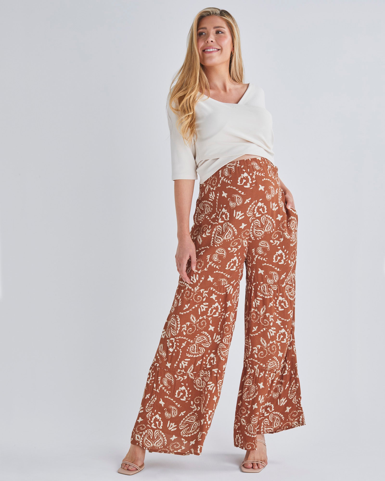 A Pregnant Woman Wearing Stacie Wide Leg Maternity Ruffled Pants in Paisley Print from Angel Maternity