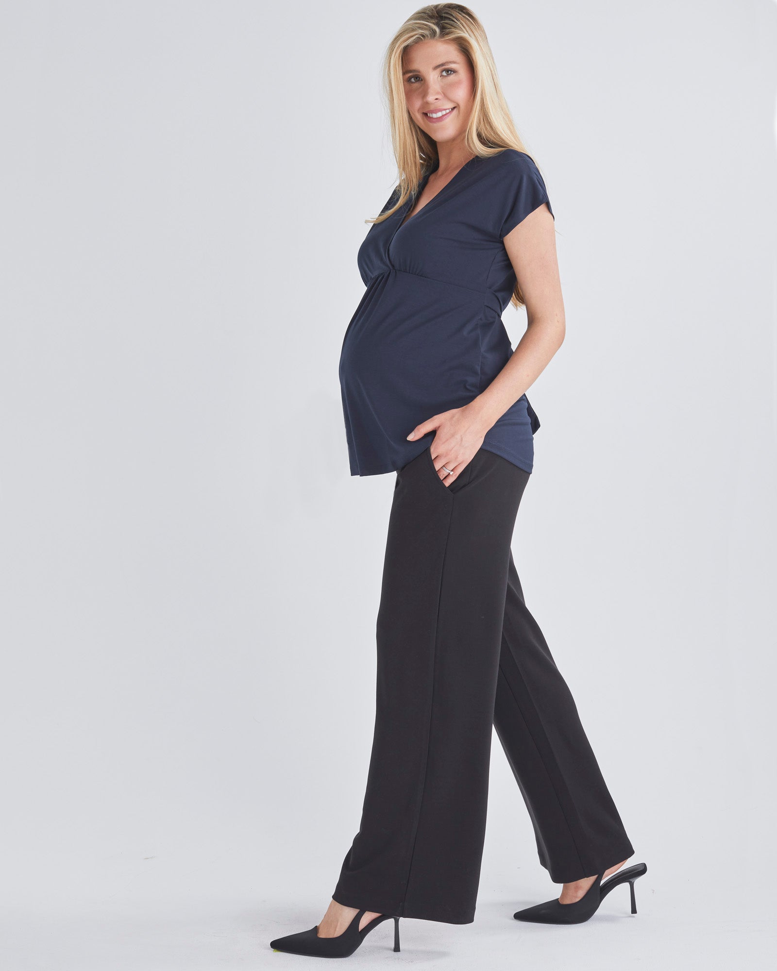 Side View - A Pregnant Woman Wearing Short Sleeve Nursing Friendly Maternity Crossover Navy Work Top  from Angel Maternity