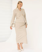 Woman wearing a beige suit with a white background