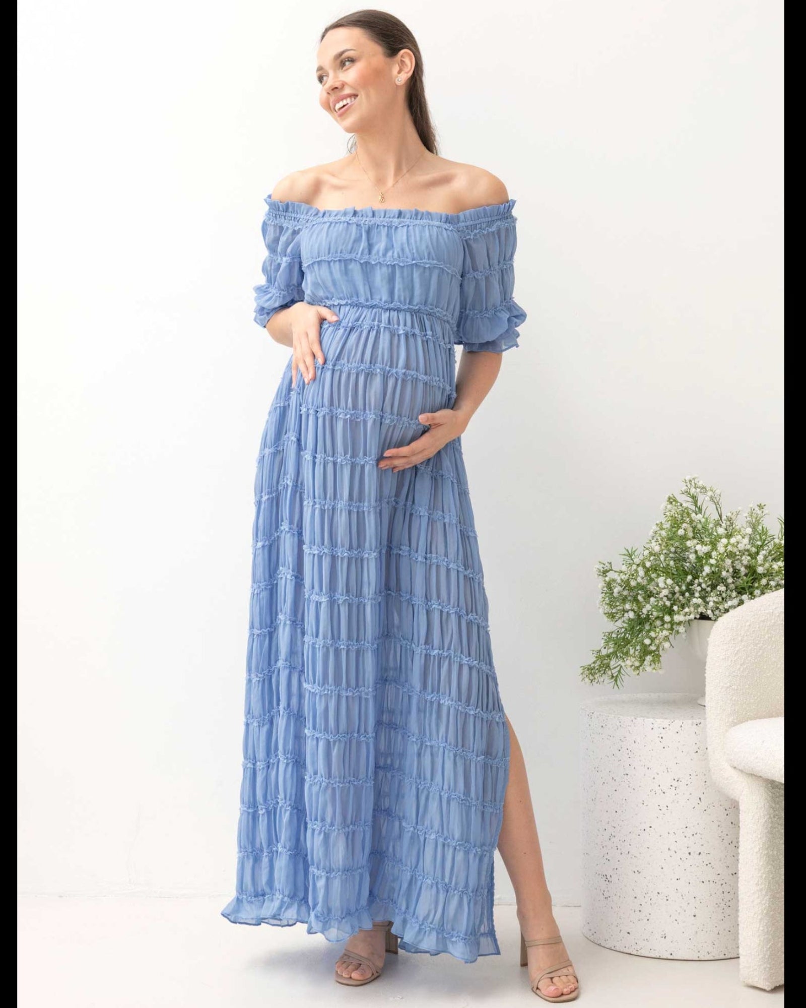 Woman wearing a blue off-shoulder dress with a white background