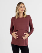 Pregnant Woman wearing a maroon long-sleeve nursing top on a white background