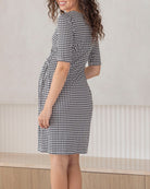 working mum wearing a black and white checkered  maternity dress in office