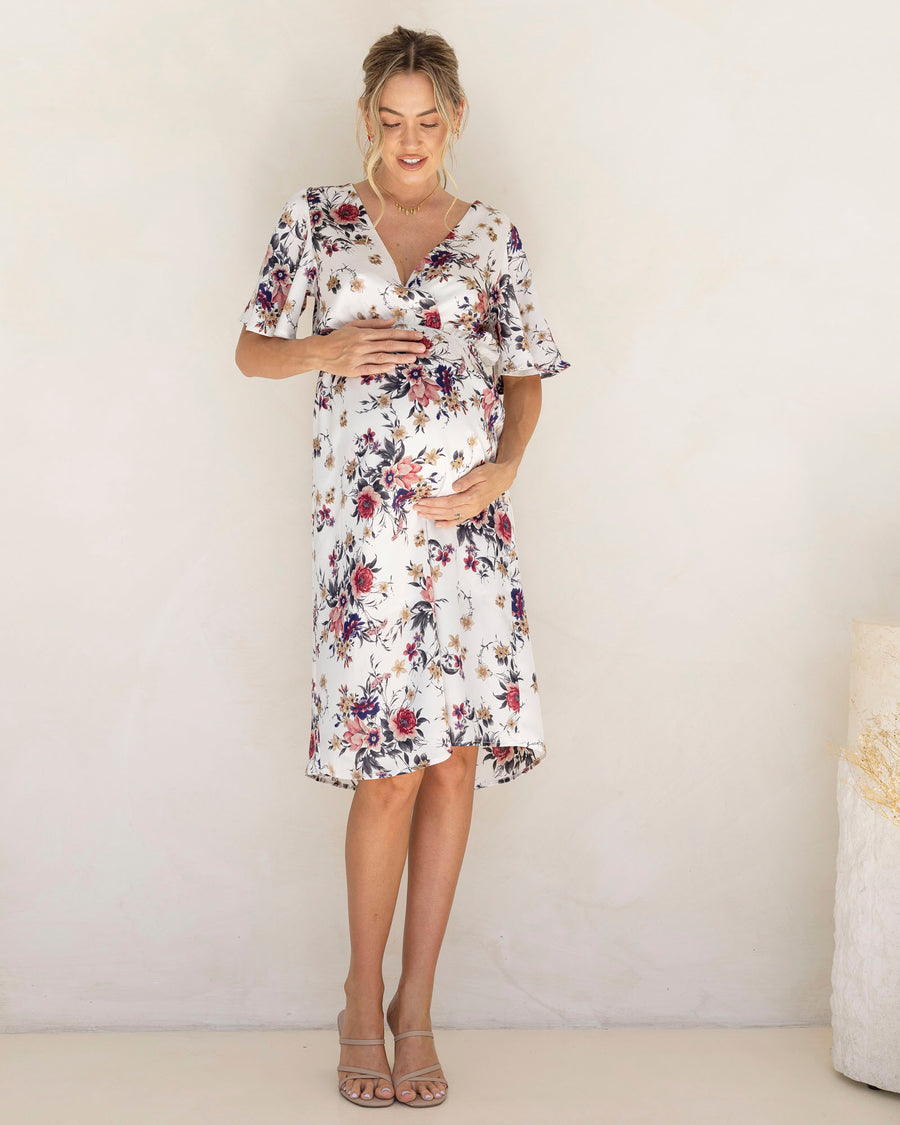 Woman wearing a floral maternity satin dress for baby shower