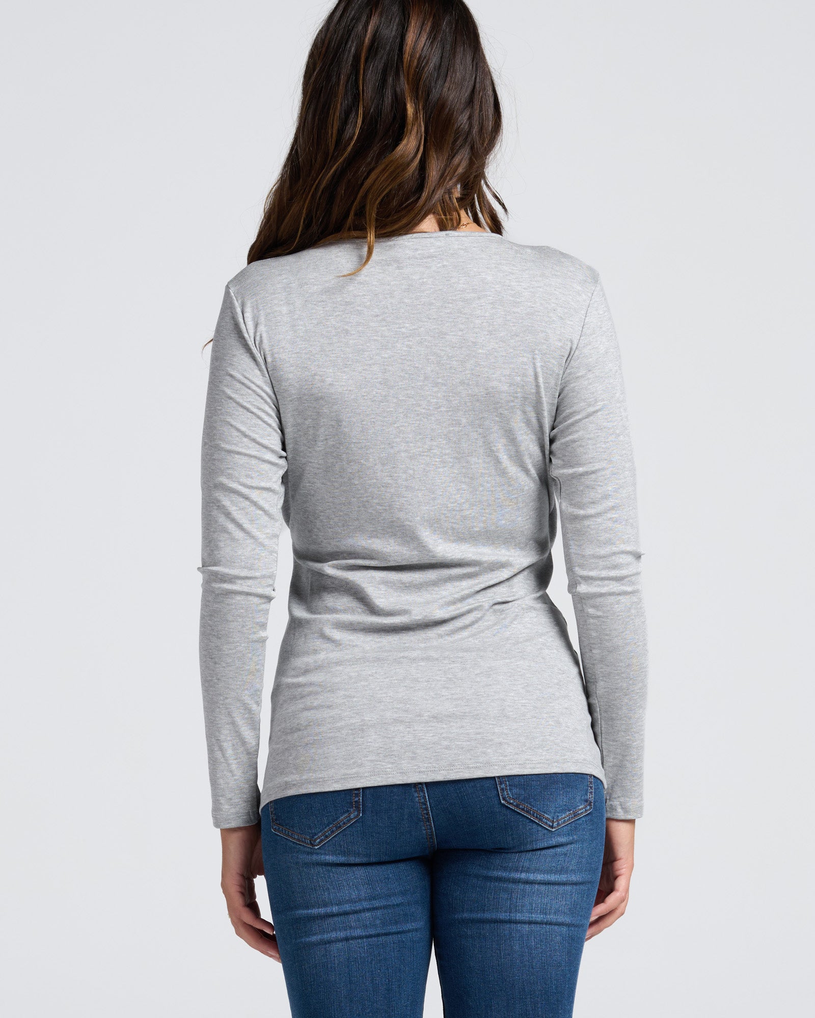 Person wearing a gray maternity  long-sleeve top and blue denim maternity jeans 