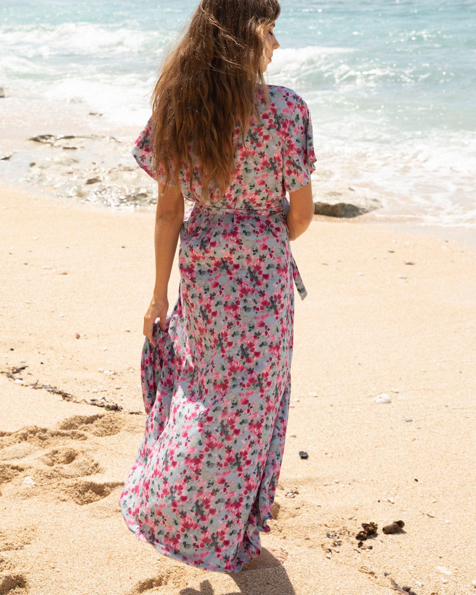 Back View - A pregnant Woman in Floral Pink Nursing Friendly Maternity Wrap Dress  on the Beach